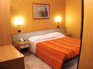 Habitación de hotel con cama y teléfono en Hotel Isolabella, en Bussoleno