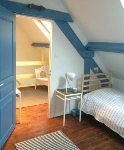 um quarto com uma cama e uma secretária com um candeeiro em Ivy House Utah Beach em Sainte-Marie-du-Mont