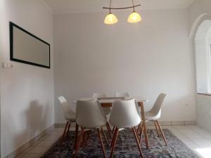 a dining room with a table and white chairs at Baross Apartman in Tapolca +15 photos