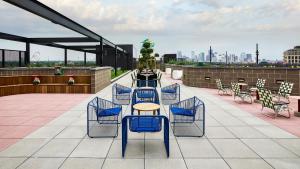 a patio with a table and chairs on a roof at Catbird Hotel in Denver