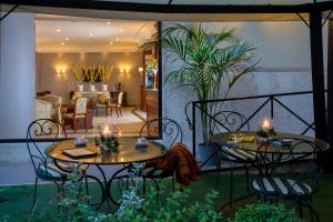 un patio avec deux tables et des chaises ainsi qu'un salon dans l'établissement Hotel Santa Costanza by OMNIA hotels, à Rome