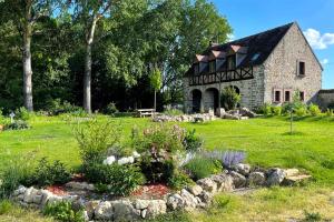 a garden in front of a stone house at Architecte Les 3 arches de Dormelles in Dormelles