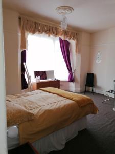 - une chambre avec un grand lit et une fenêtre dans l'établissement Sunrise Apartments, à Llandudno
