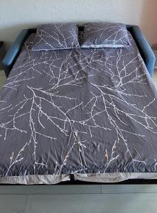 ラ・グランド・モットにあるStudio Piscine à 5 minutes des plages du couchantの白い蜘蛛の巣が描かれた黒い掛け布団が敷かれたベッド