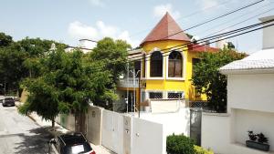 uma casa amarela com uma cerca branca à frente. em Departamento céntrico, perfectamente ubicado, dos habitaciones em Cancún