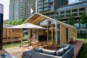 a small house on a deck with a table and an umbrella at Wikkelboats at Floating Rotterdam Rijnhaven in Rotterdam