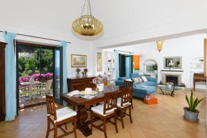 uma sala de jantar e sala de estar com mesa e cadeiras em Villa La Leonessa em Positano