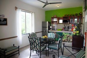 uma cozinha com uma mesa e cadeiras e uma parede verde em Departamento céntrico, perfectamente ubicado, dos habitaciones em Cancún