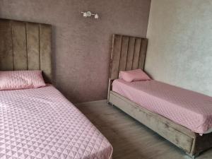 two beds in a room with pink sheets at Taghazout Bay in Taghazout