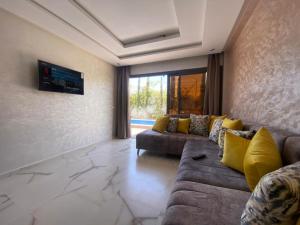 uma sala de estar com dois sofás e uma televisão em VILLA AMALOU AVEC PISCINE FAMILLE UNIQUEMENt em Agadir