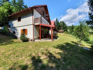 a house on top of a grassy hill with trees at Forest house Masha in Mrkopalj