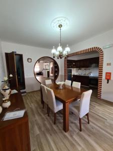 una sala da pranzo con tavolo in legno e sedie bianche di Casa Fortunato a Casais Brancos