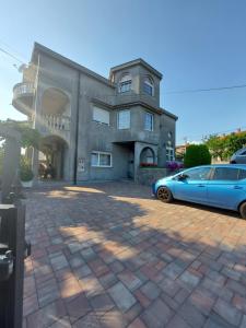 a blue car parked in front of a house at Apartman Palma in Rijeka