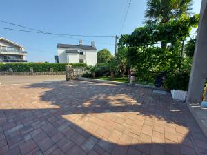 a brick driveway with trees and a building at Apartman Palma in Rijeka