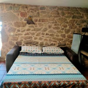 ein Sofa in einem Zimmer mit einer Steinmauer in der Unterkunft Eirixo in Valga