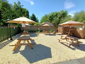 
a patio area with chairs, tables and umbrellas at The Harp Inn in Glasbury
