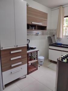 a kitchen with a white refrigerator and a table at Casa da Andrea Imbassai in Imbassai