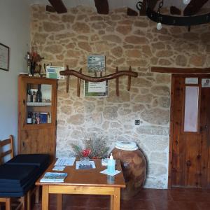 a room with a table and a stone wall at Masia Del Aragones in Peñarroya de Tastavins