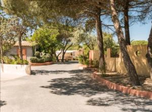 a driveway with trees in front of a house at MOBIL HOME camping **** Canet en Roussillon in Canet-en-Roussillon