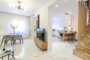 cocina y sala de estar con mesa y sillas en Aikanto residence, en Agios Nikolaos