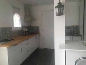 a kitchen with white cabinets and a window at Loft 1 in La Trinité