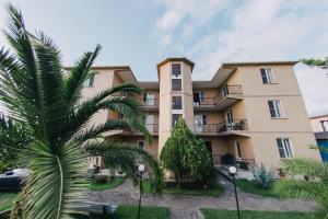 un edificio con una palma di fronte di Nika Inn Kobuleti a Kobuleti