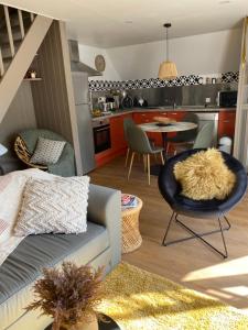 a living room and kitchen with a couch and a table at La Maisouneta in Cazeaux-de-Larboust