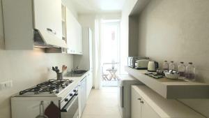 a white kitchen with a stove and a sink at Heart Milan Apartments Fashion District in Milan