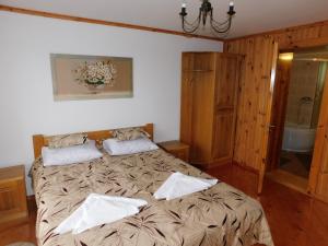 a bedroom with a large bed with two pillows on it at Glanz Cottage in Yaremche