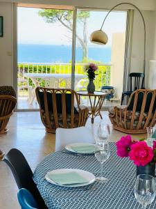 tavolo con sedie e tavolo con vista sull'oceano di Villa Simone vue mer 2min à pied de la plage a Saint-Lunaire