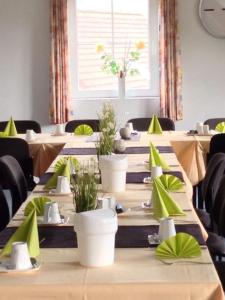 una fila de mesas en una habitación con servilletas verdes en Hotel am Maibaum, en Neuenrade