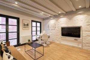 ein Wohnzimmer mit Fernseher und Tisch in der Unterkunft ART Boutique in A Coruña