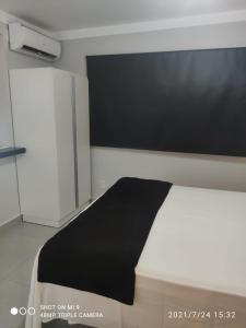 Loft Unique في ريبيراو بريتو: غرفة نوم مع سرير وبطانية سوداء