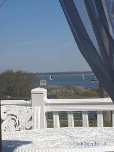 balkon z białym płotem i widokiem na wodę w obiekcie Modern Sea View Holiday Home Isle of Wight w mieście Porchfield