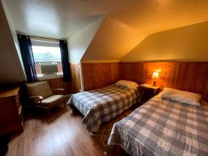 um quarto de hotel com duas camas e uma janela em The Riverside Inn em Stowe