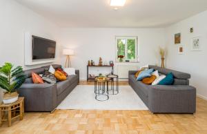 a living room with two couches and a tv at 2OG Rechts - Wunderschöne 80m2 3-Zimmer City Wohnung nähe Salzburg in Freilassing