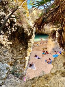 a group of people laying on a sandy beach at Albufeira Oldtown 330ft Beach Private garage AC Wifi in Albufeira