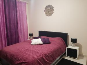 een slaapkamer met een bed met een rode deken en paarse gordijnen bij Chambres d'hôte in Sennecey-le-Grand