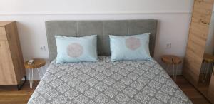 ein Schlafzimmer mit einem Bett mit zwei blauen Kissen in der Unterkunft Atlantis Atmosphere Apartment in Burgas City