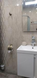 a bathroom with a sink and a toilet paper dispenser at Atlantis Atmosphere Apartment in Burgas City +34 photos