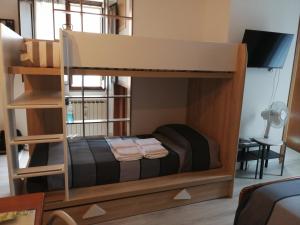 a bunk bed in a room with a tv and a bed at B&B Petra Castalda in Sasso di Castalda