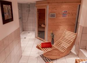 a bathroom with a shower and a chair in a room at Haus Heimat Wagrain in Wagrain