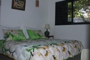 um quarto com uma cama com almofadas verdes e uma janela em Maison Etoile De Mer 1 em Skhirat