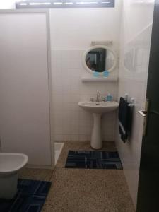 uma casa de banho branca com um lavatório e um espelho em Maison Etoile De Mer 1 em Skhirat