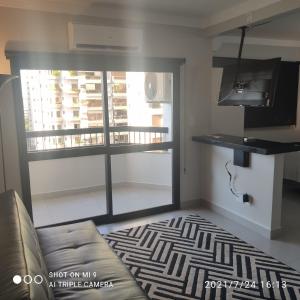 a living room with a window and a couch at Loft Unique in Ribeirão Preto