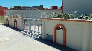 a white fence with plants on top of a building at L'orientale in Saïdia +2 photos