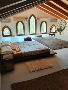 a bedroom with a large bed and two rugs at Granja Masia Katmandu in Cretas