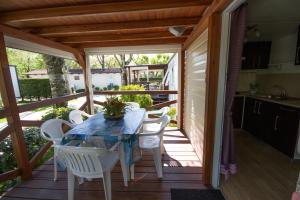 a patio with a table and chairs on a deck at Camping Santin in Cavallino-Treporti