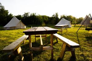 a picnic table and two tents in a field at GLAMPNORD in Bodø