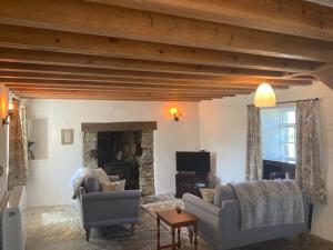 a living room with two couches and a tv at Picture perfect cottage in rural Tintagel in Tintagel